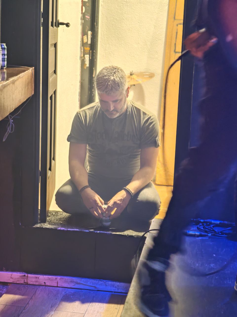 Ritual de Merino en la puerta del backstage sentado en el suelo antes de la actuación