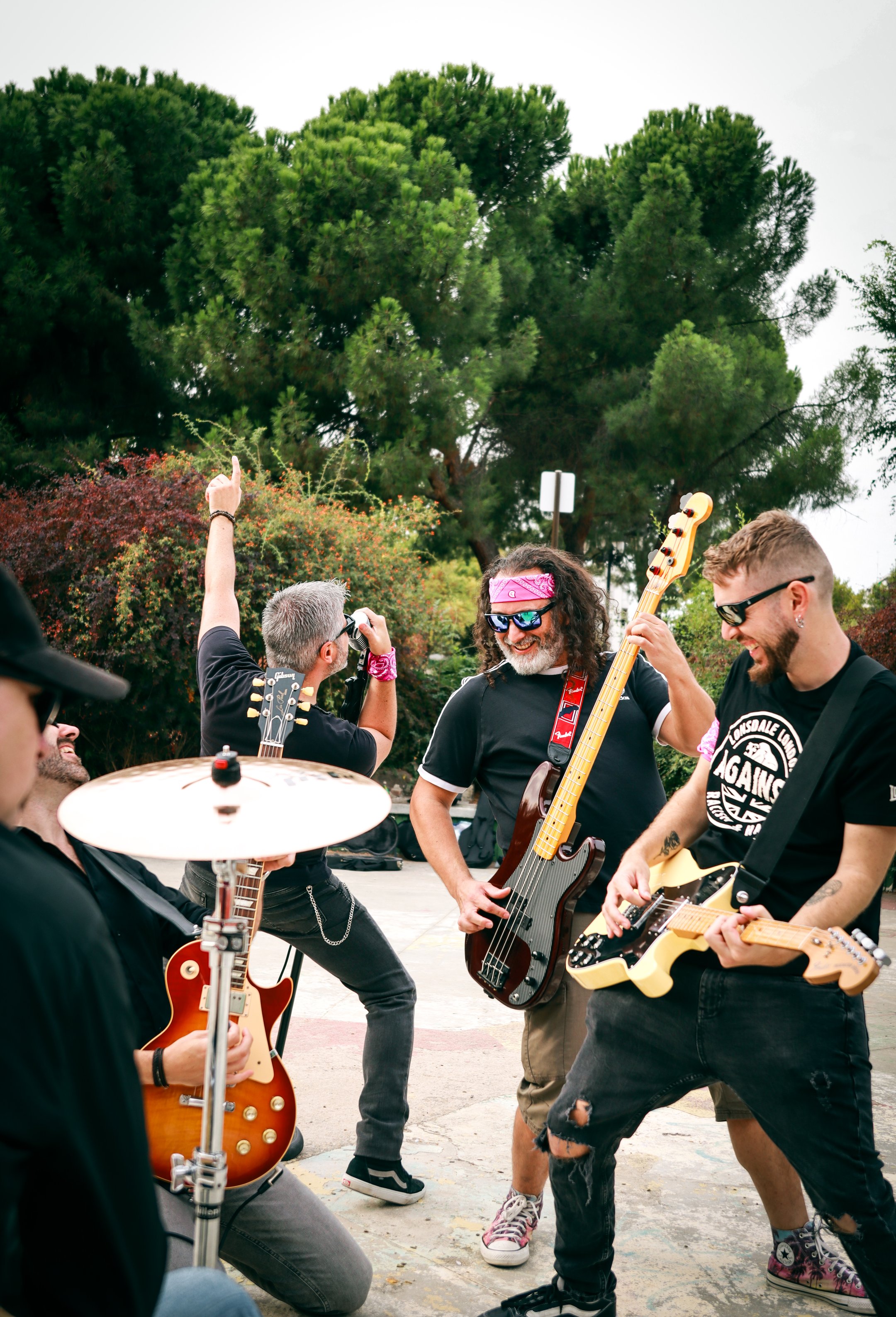 Momento divertido de los miembros de Arrojo ensayando al aire libre con guitarras, bajo y platillo