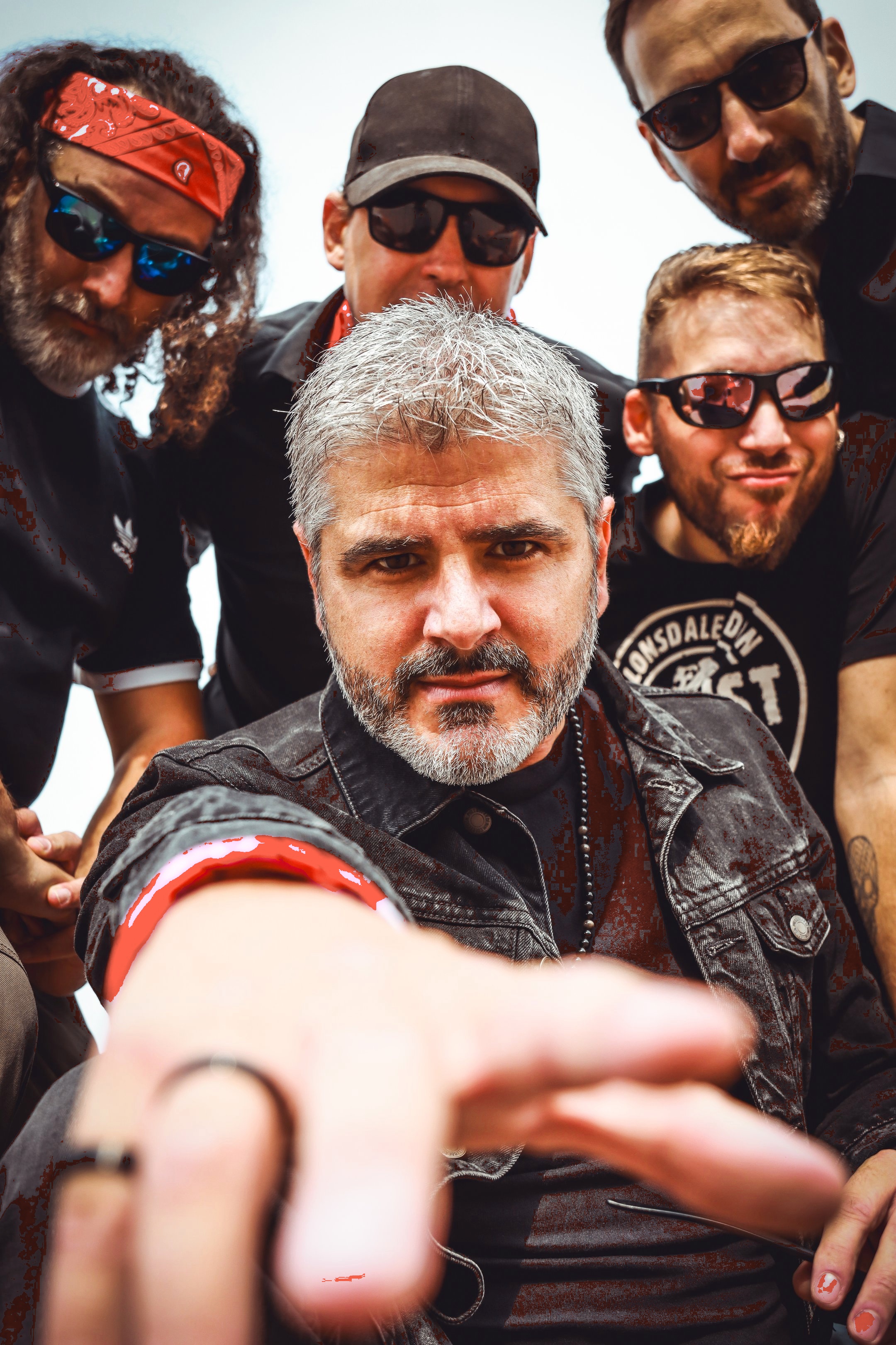 Primer plano de todos los integrantes de Arrojo mirando a cámara con actitud rockera