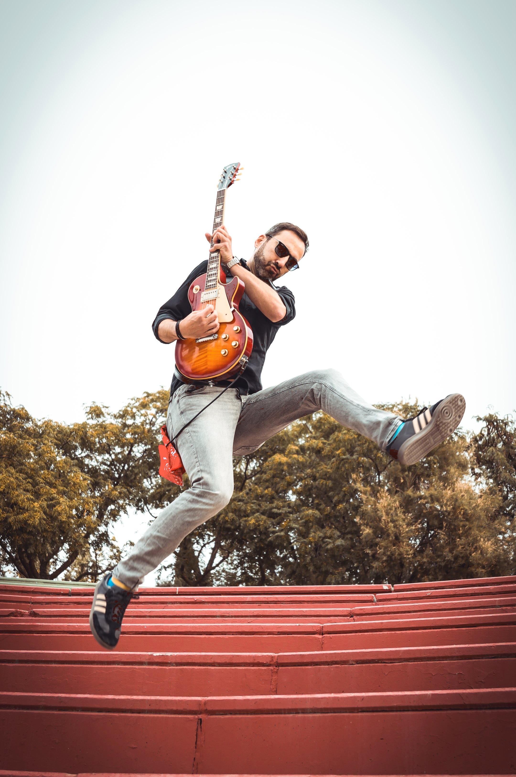 Guitarrista solista Yor dando un salto en el aire mientras toca su guitarra Les Paul