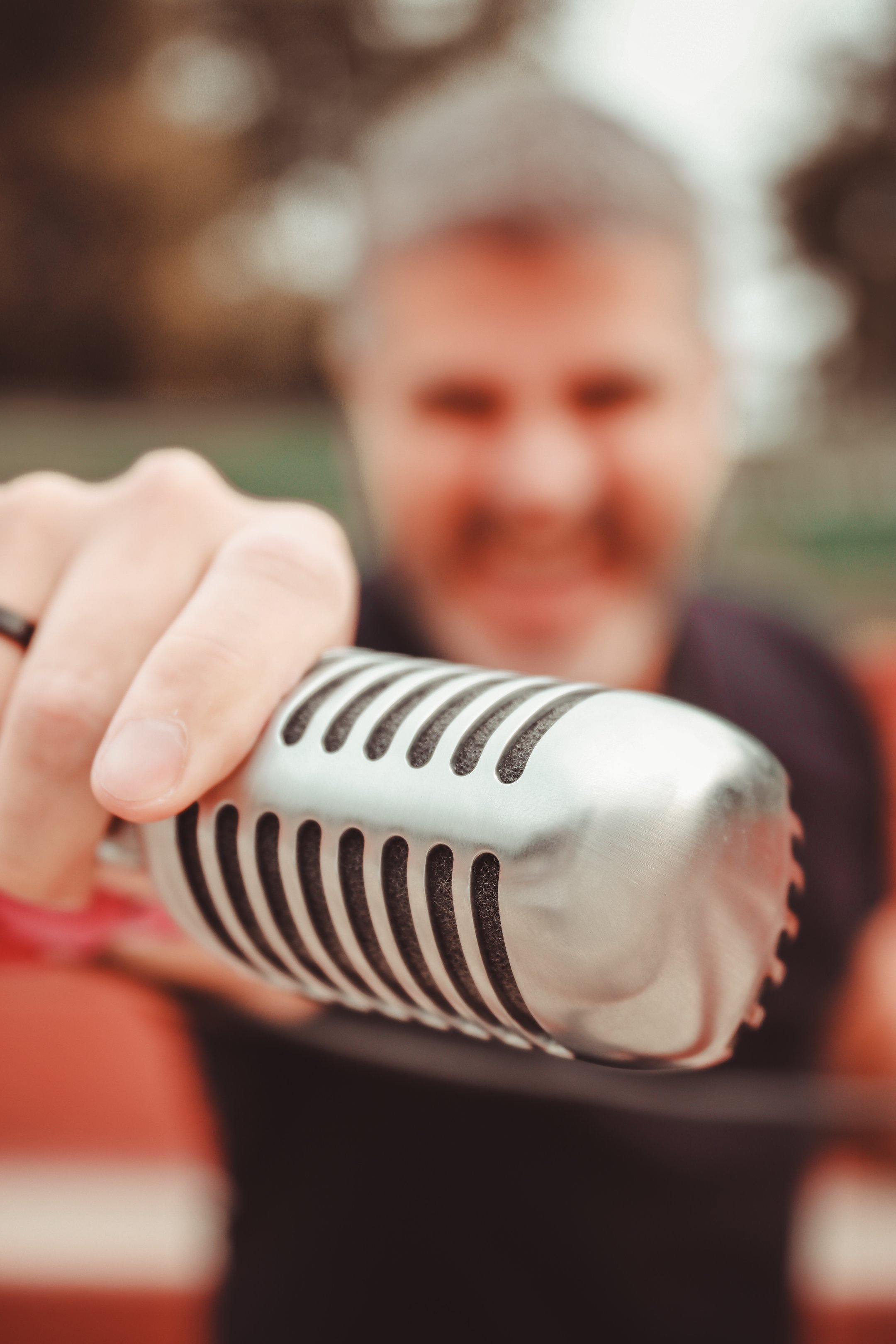 Primer plano de micrófono de estilo vintage con el cantante de Arrojo al fondo